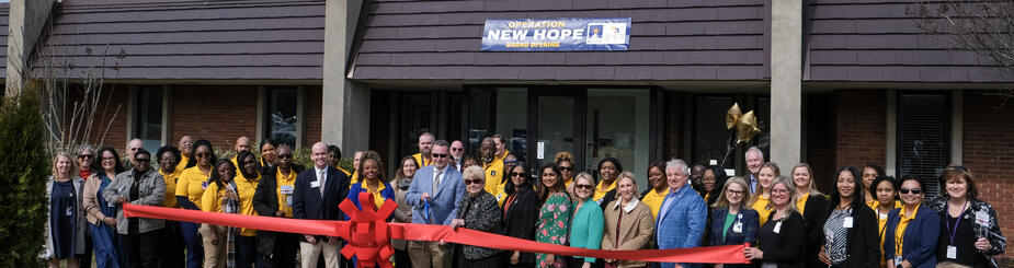A group of employees and invitees standing in from of the new Operation New Hope building at West Central Georgia Regional Hospital